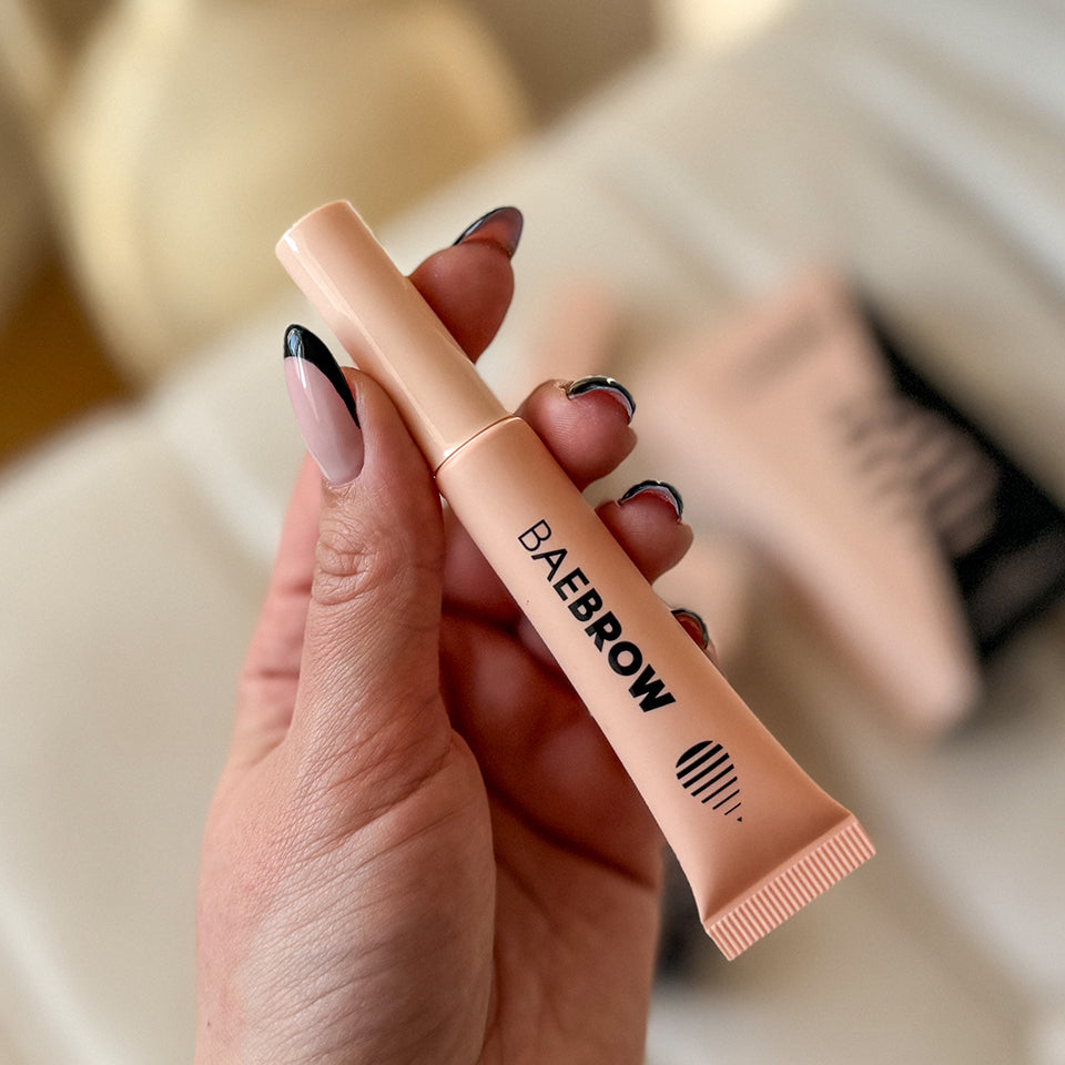 Revitalising Brow Gel with 'BAEBROW' branding held by a hand on a light background