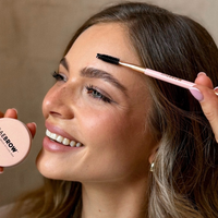 Woman getting her eyebrows done with a BAEBROW brow styling brush